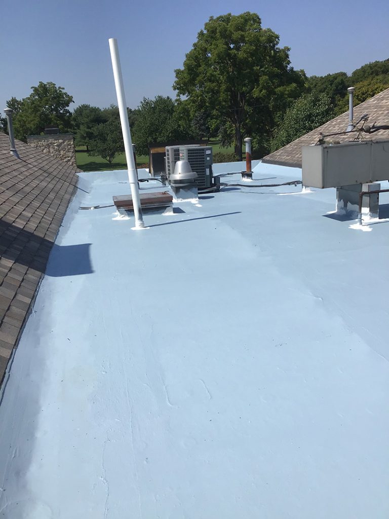 Rooftop HVAC units and penetrations on a restored flat commercial roof